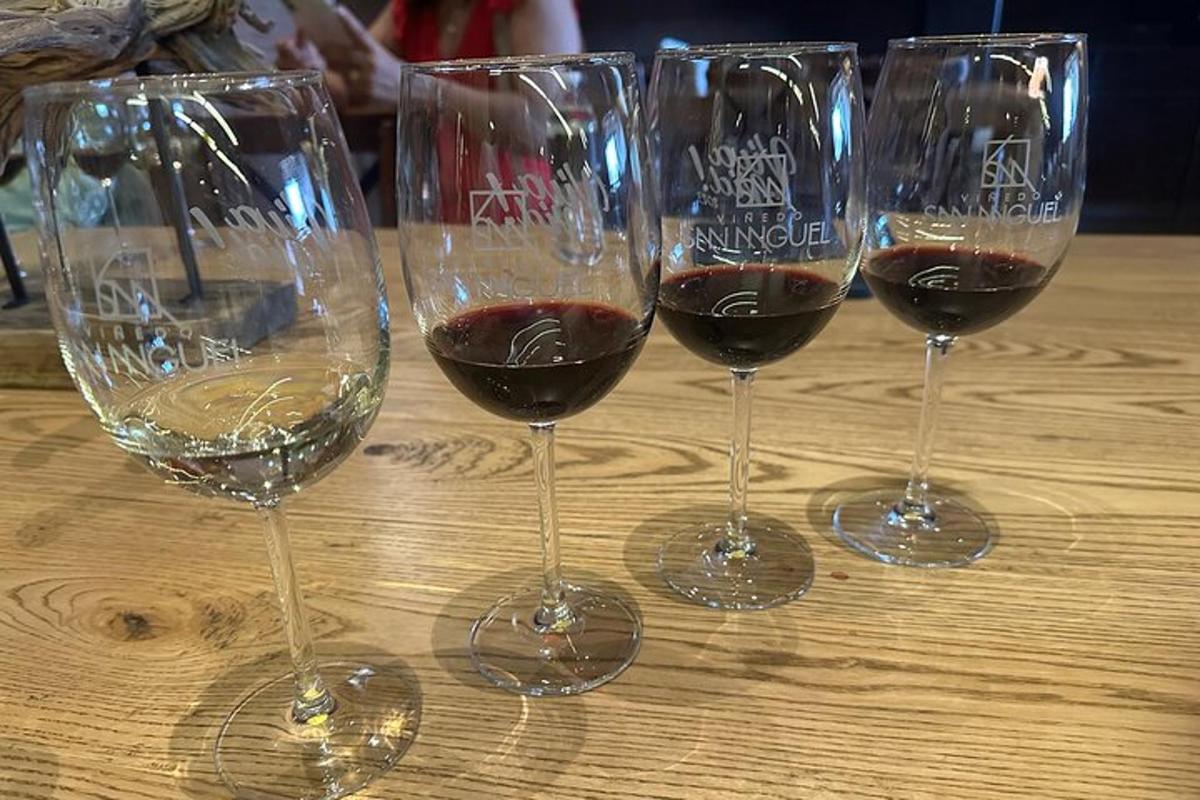 quattro bicchieri di vino appoggiati su un tavolo di legno