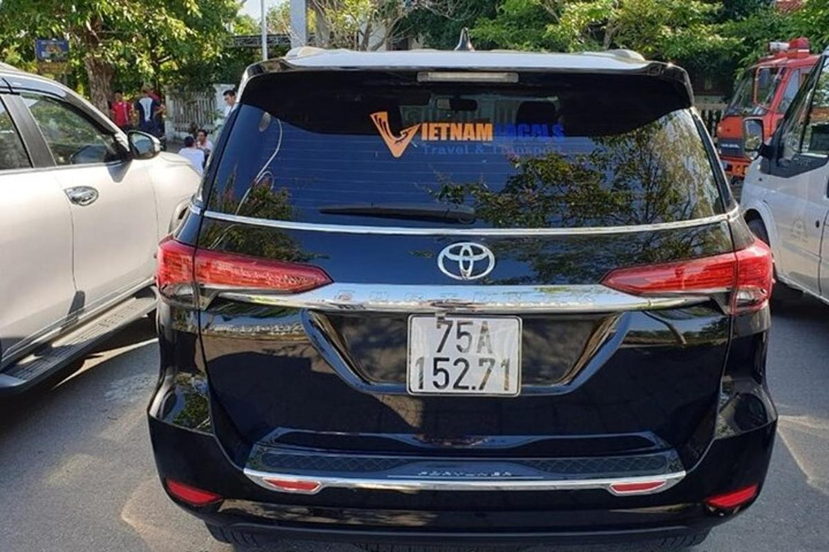 Una vista trasera de un coche estacionado en un estacionamiento.