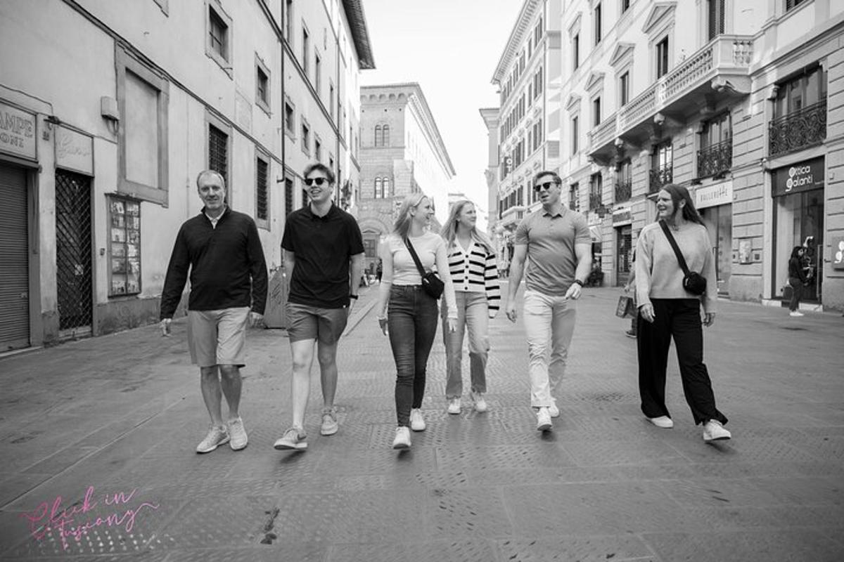 un gruppo di persone che camminano lungo una strada cittadina