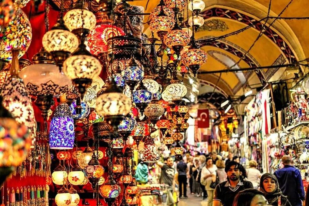 una folla di persone che camminano in un mercato illuminato