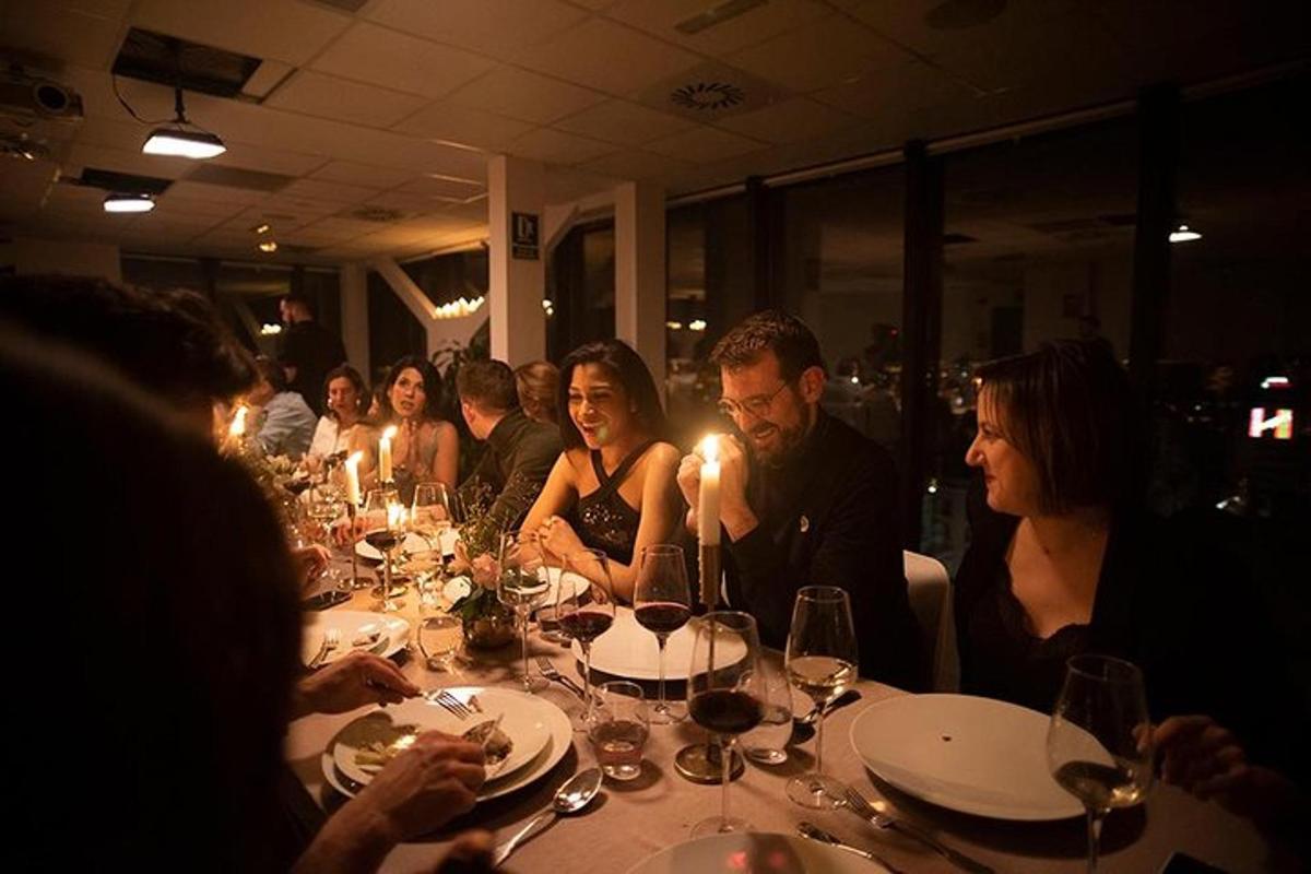 cilvēku grupa, kas sēž pie galda restorānā