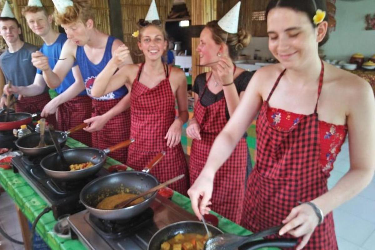 a group of people standing in a kitchen preparing food