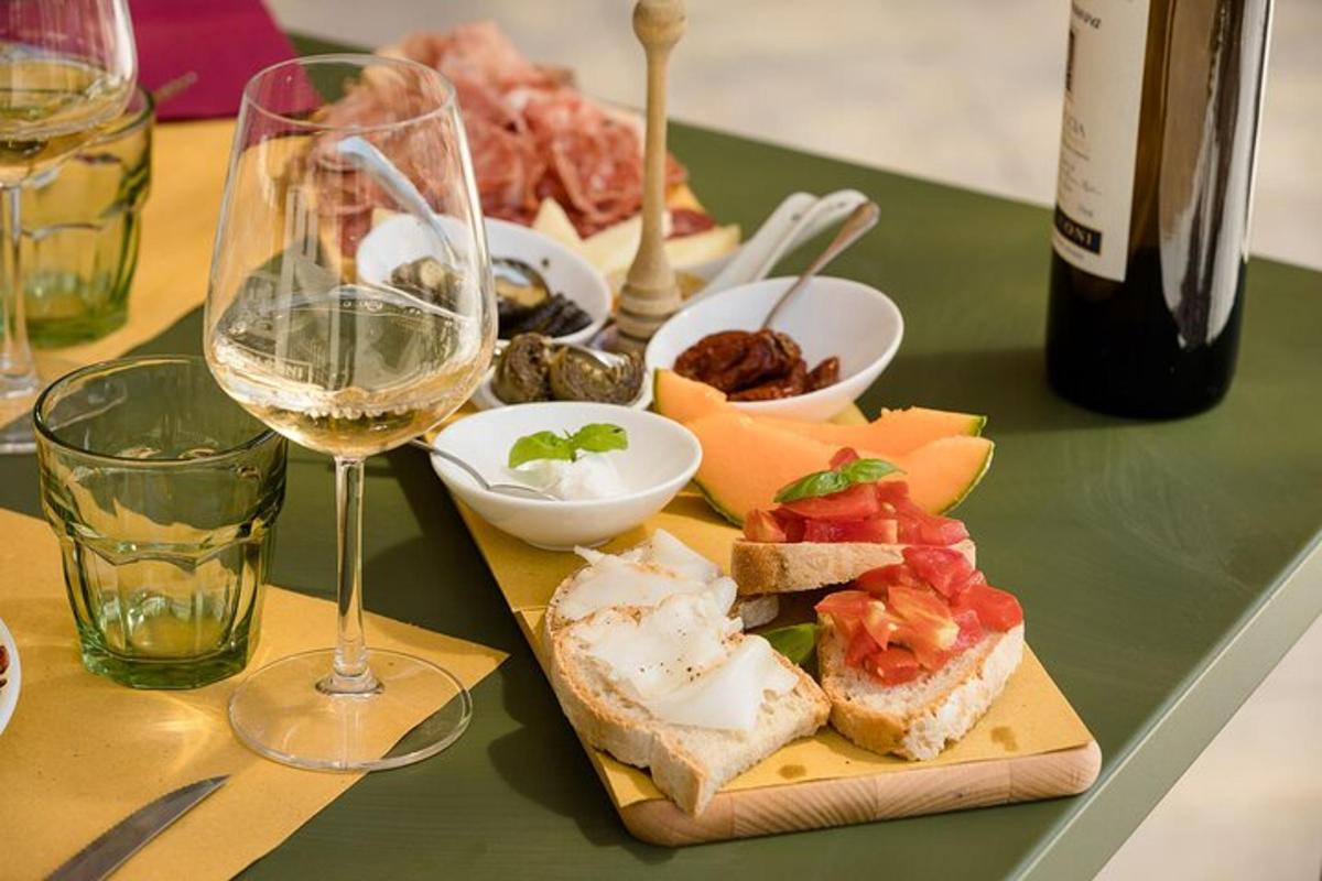 un tavolo con un piatto di cibo e un bicchiere di vino