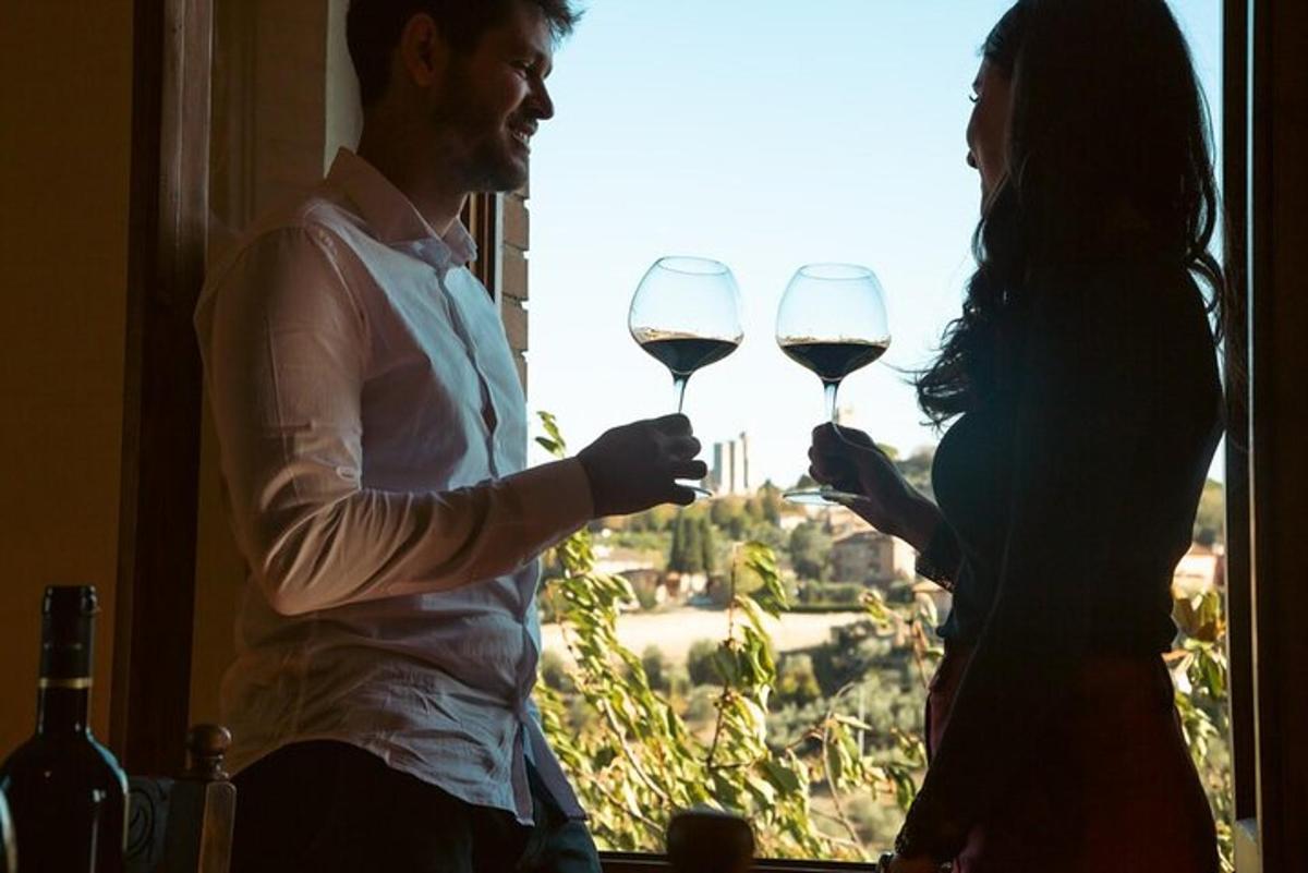 un uomo e una donna che tengono in mano dei bicchieri di vino davanti a una finestra