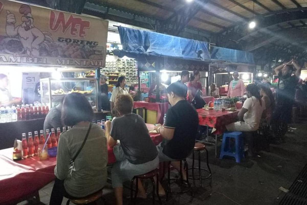 a group of people sitting at tables in a market