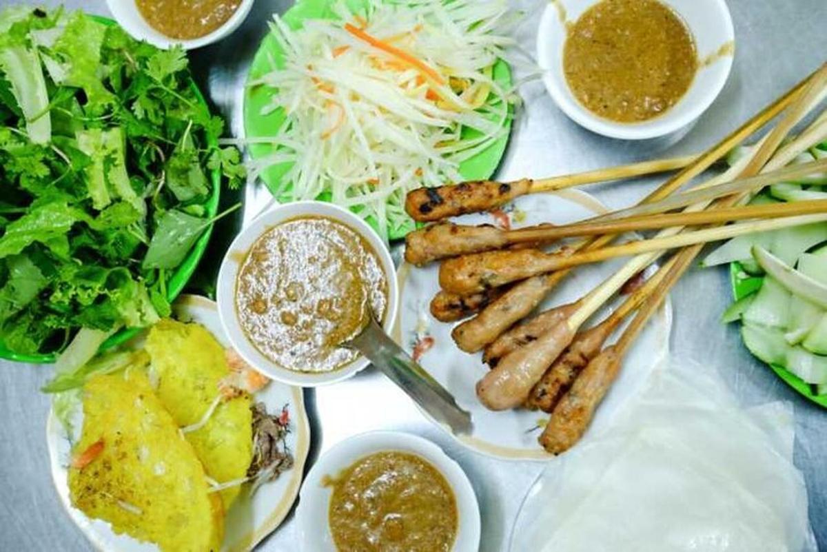 een tafel bedekt met borden met eten, eetstokjes en groenten