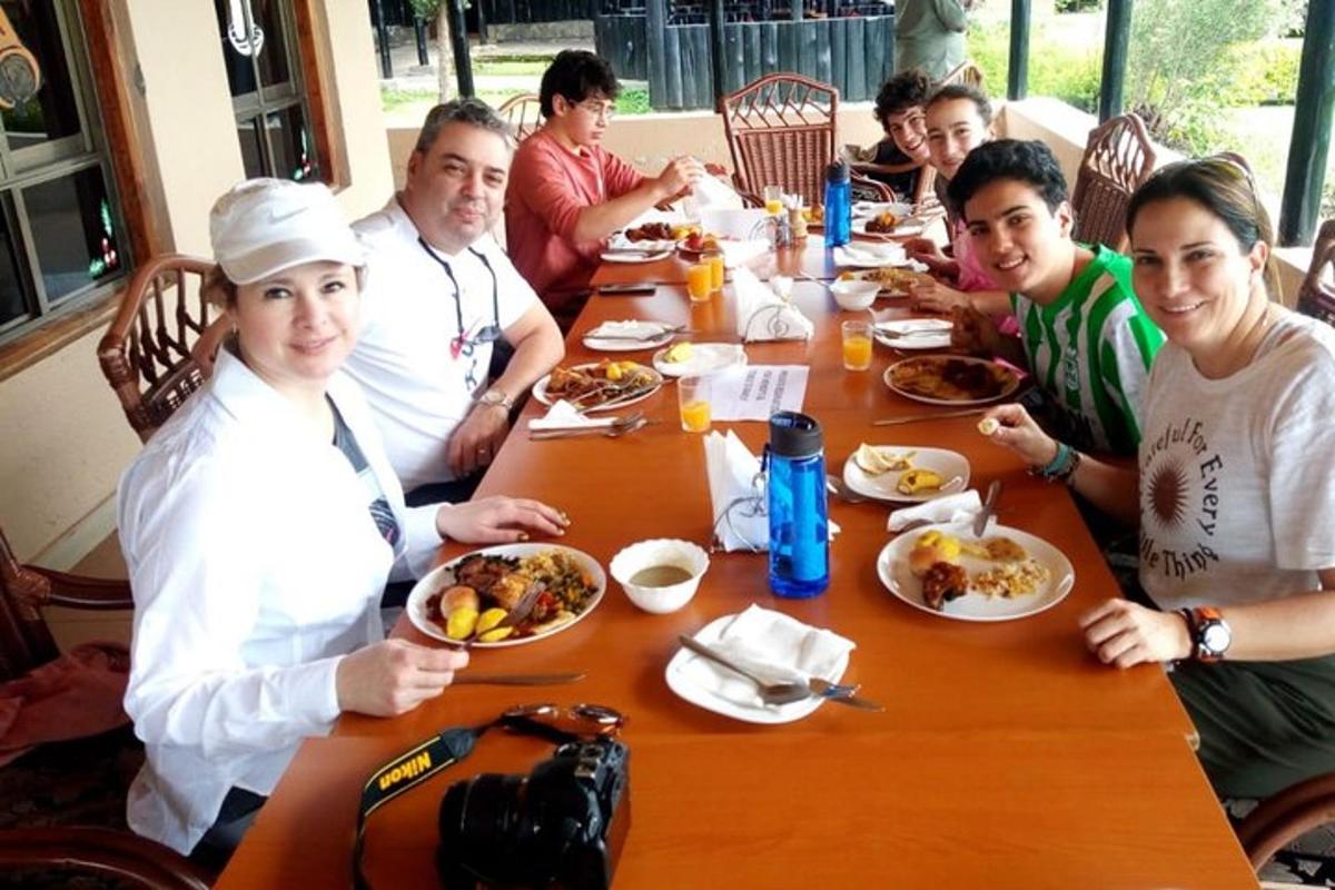 un gruppo di persone sedute attorno a un tavolo che mangiano cibo