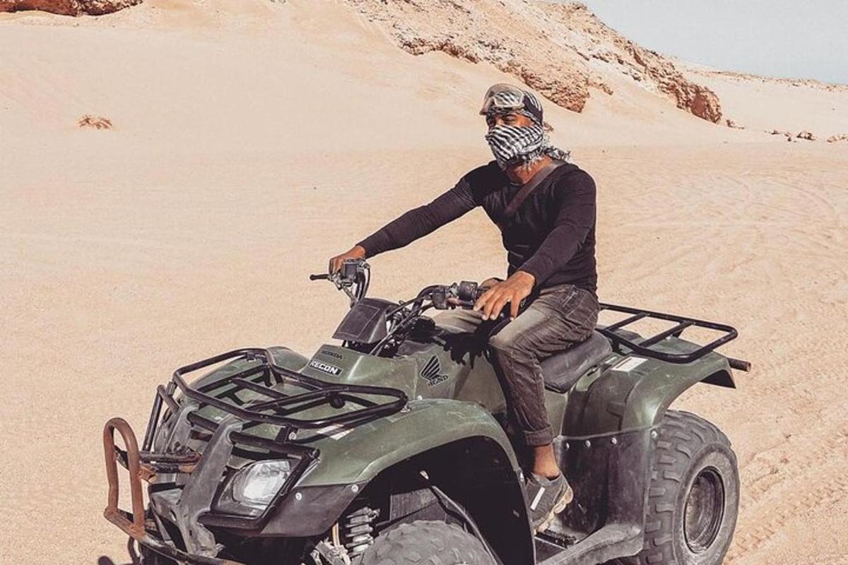 egy férfi ül egy ATV-n a sivatagban