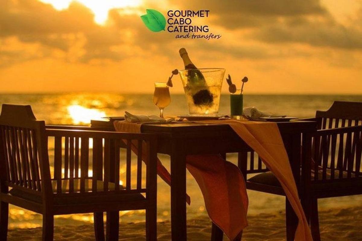 Una mesa con una botella de vino en la playa