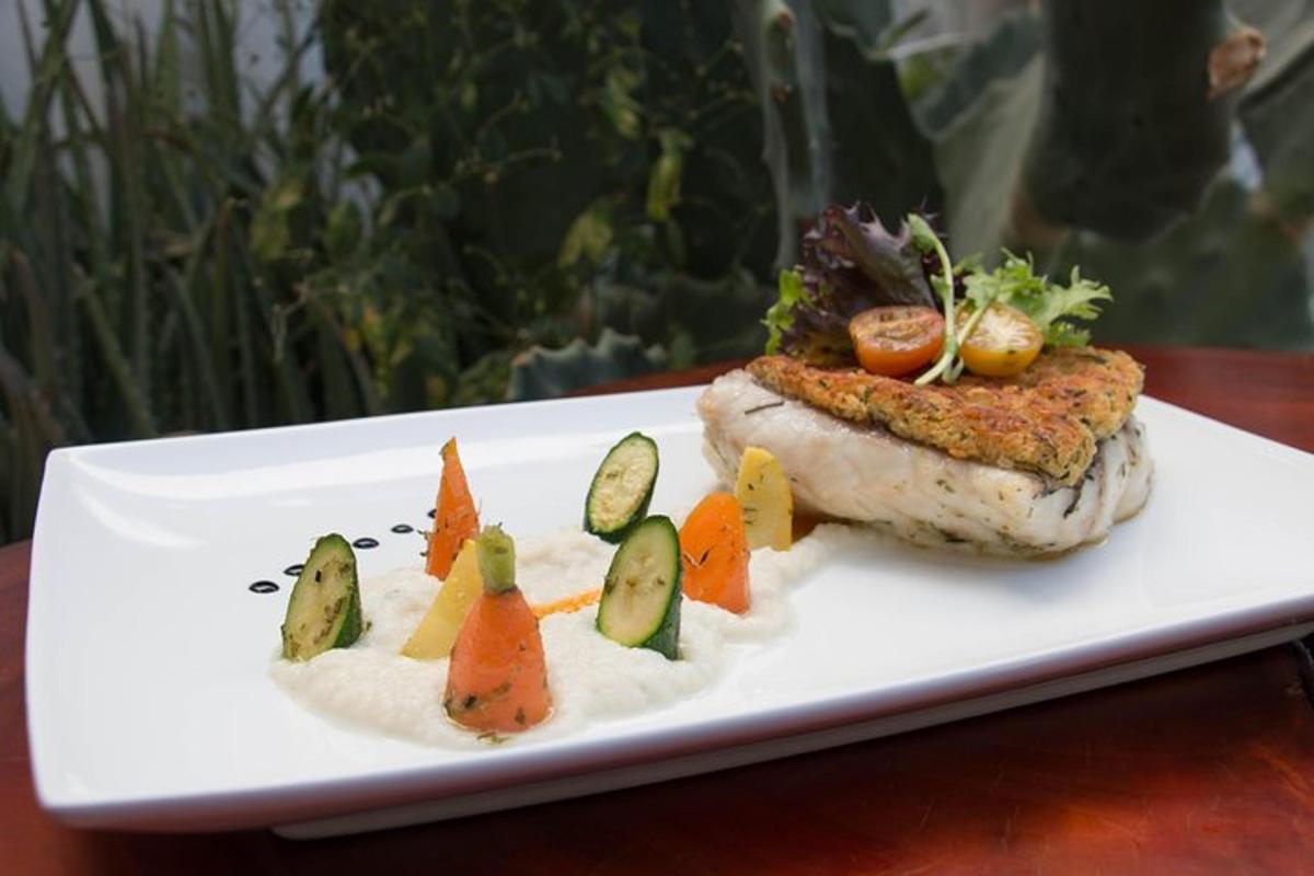 pinggan putih dengan seketul ikan dengan sayur di atasnya