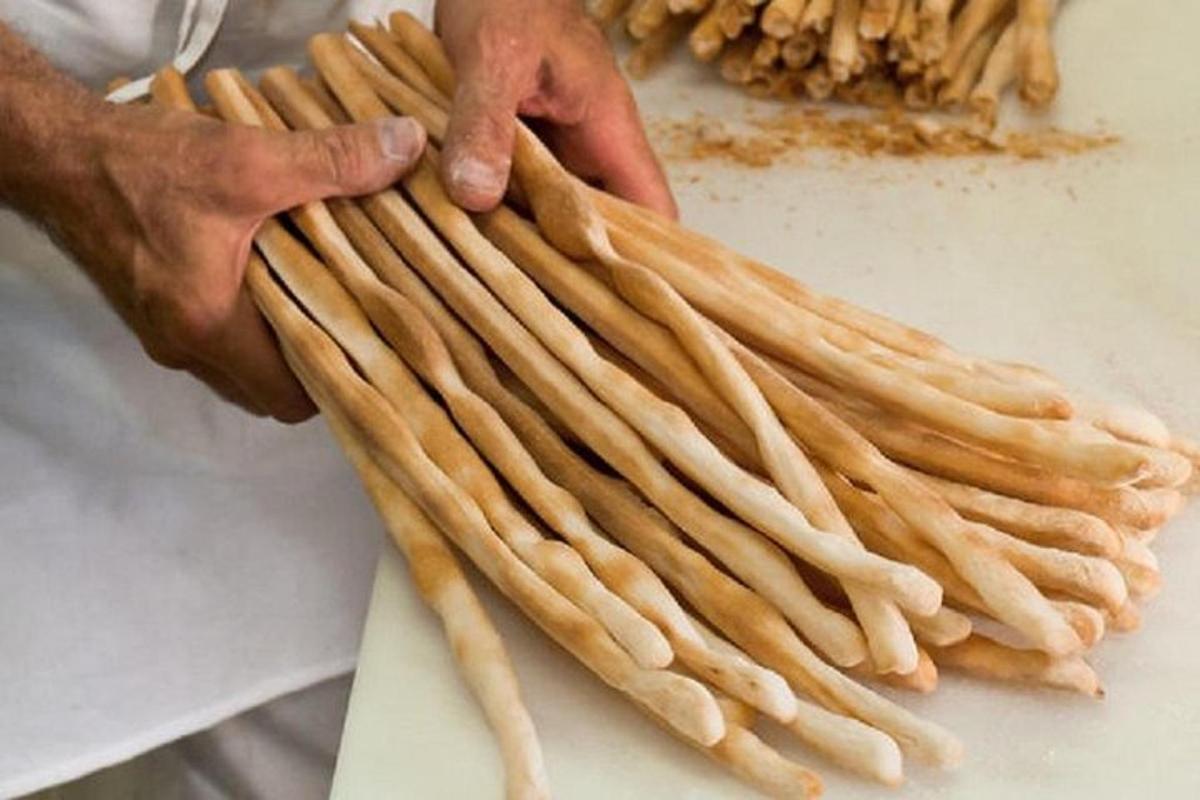 a person holding up a bunch of pasta