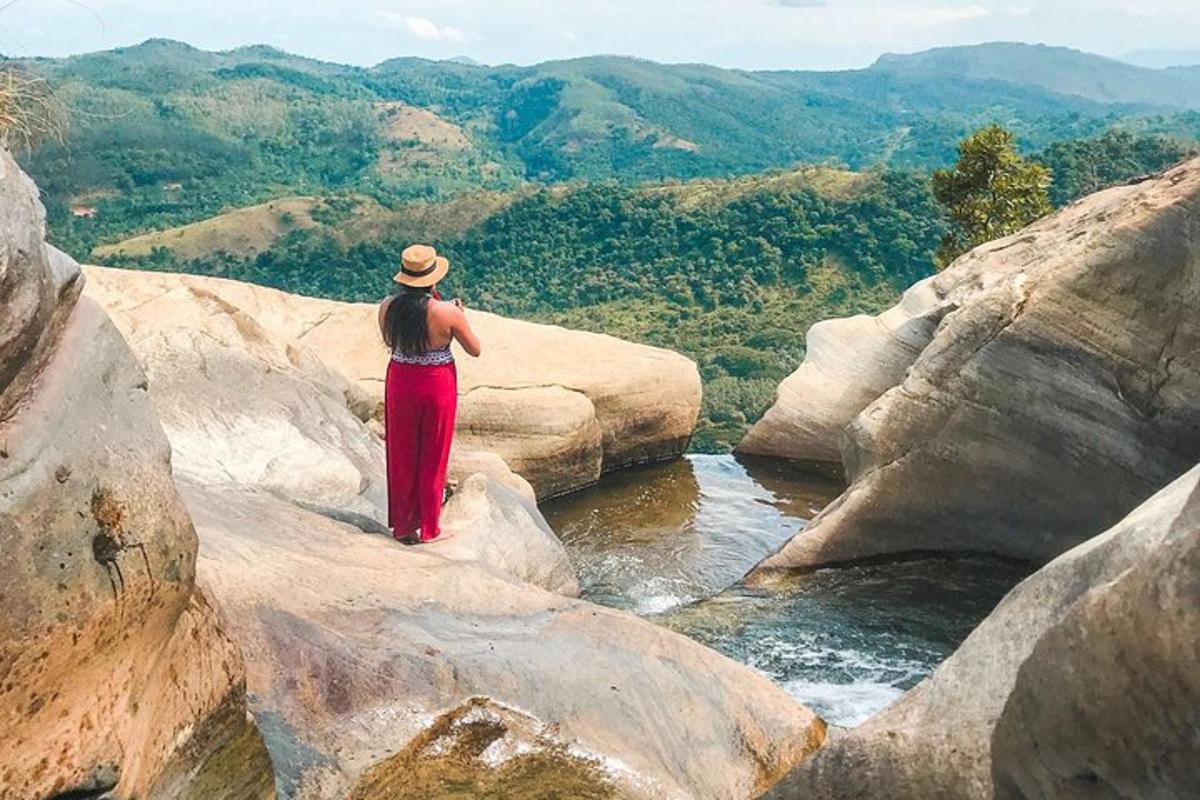 una dona dreta sobre les roques mirant un riu