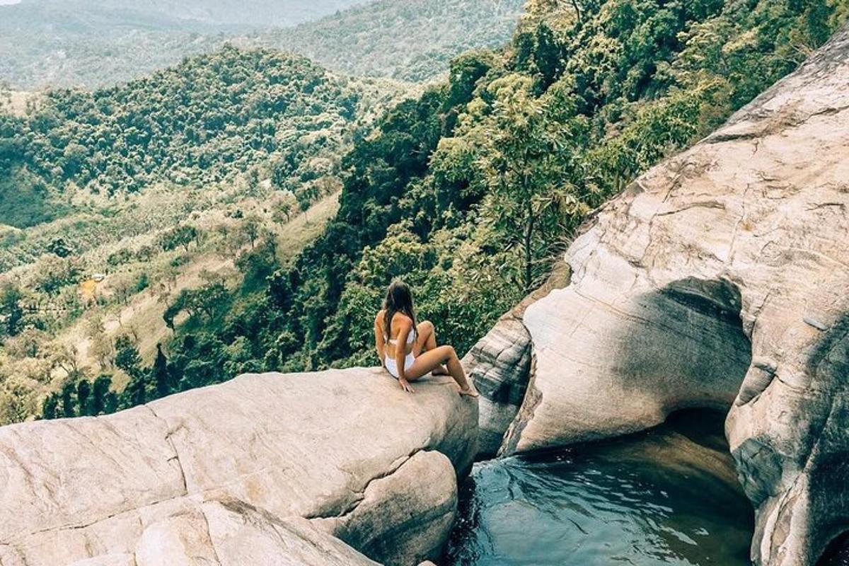 una donna seduta su una roccia vicino all'acqua