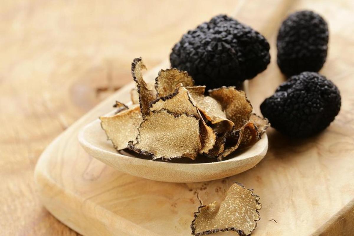 a bowl of blackberries on a wooden cutting board