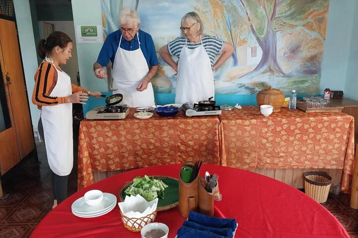 skupina ljudi, ki stojijo okoli mize in pripravljajo hrano