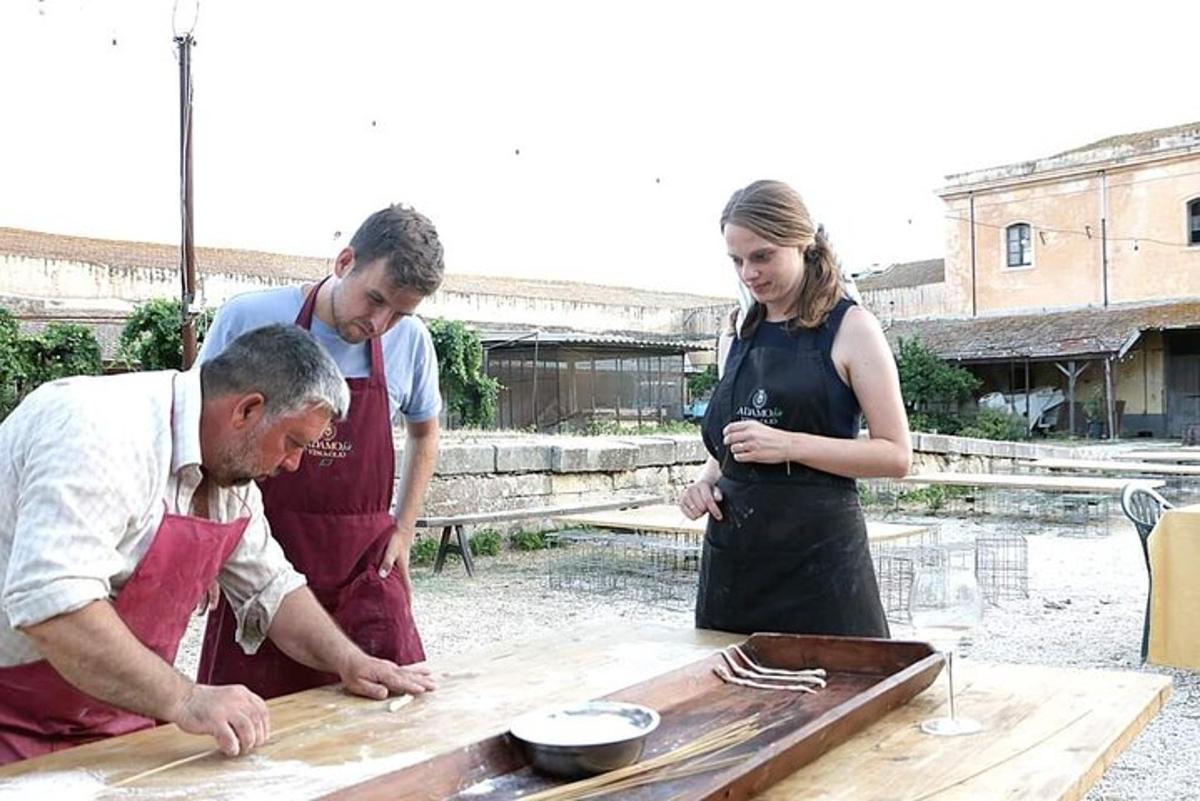 two men and a woman preparing food on a table