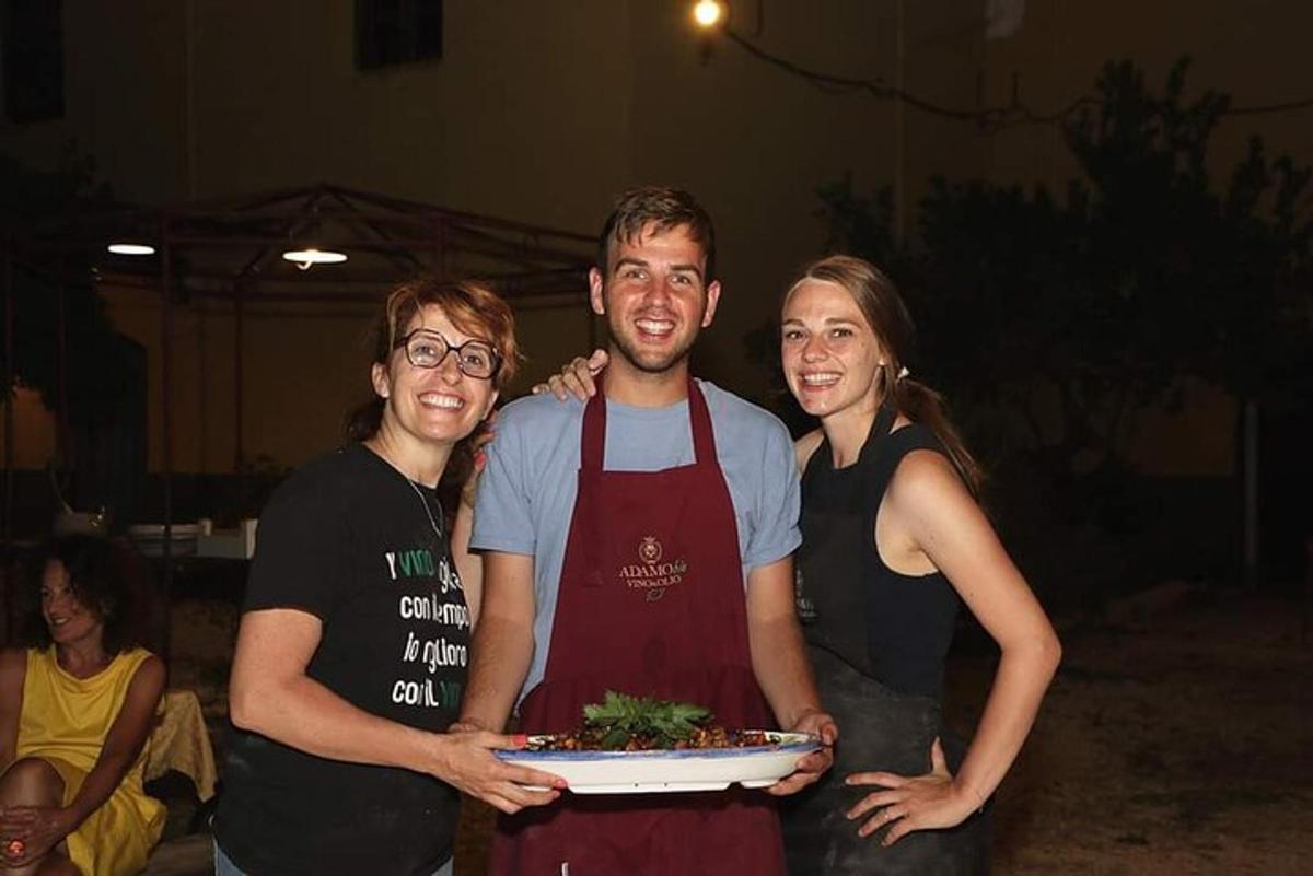 un uomo e due donne che tengono un piatto di cibo