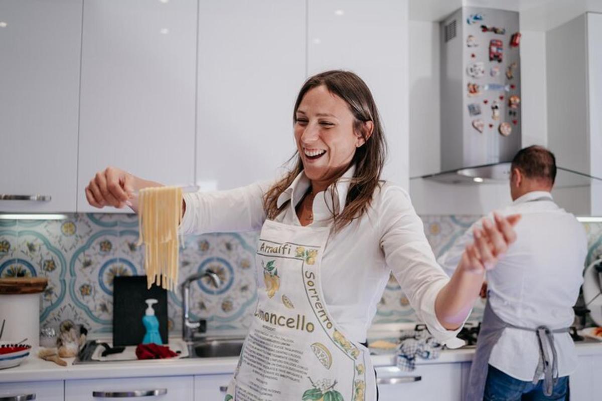 una dona a la cuina sostenint pasta