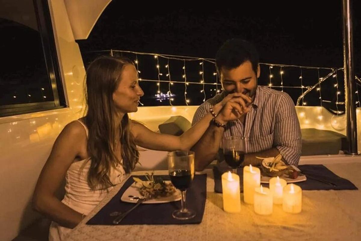 un uomo e una donna seduti a un tavolo con un piatto di cibo