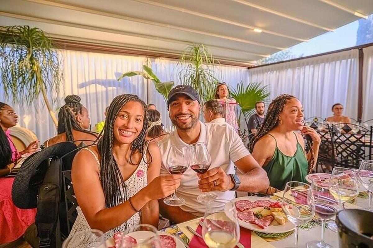um homem e uma mulher sentados à mesa com taças de vinho