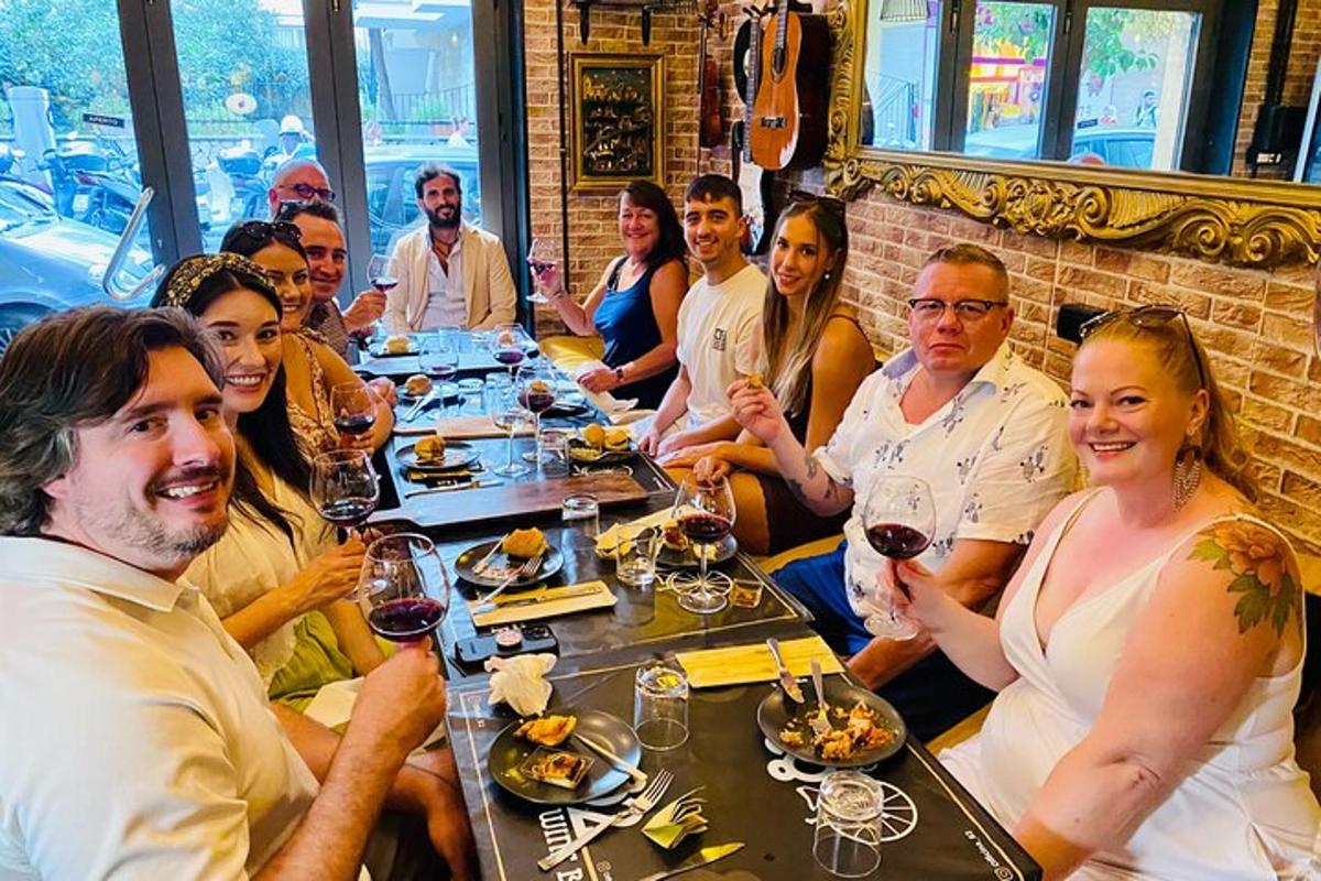 un gruppo di persone sedute a un tavolo con bicchieri di vino