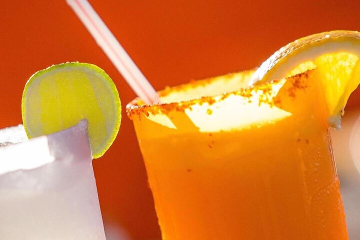 a glass of orange juice with a slice of lime