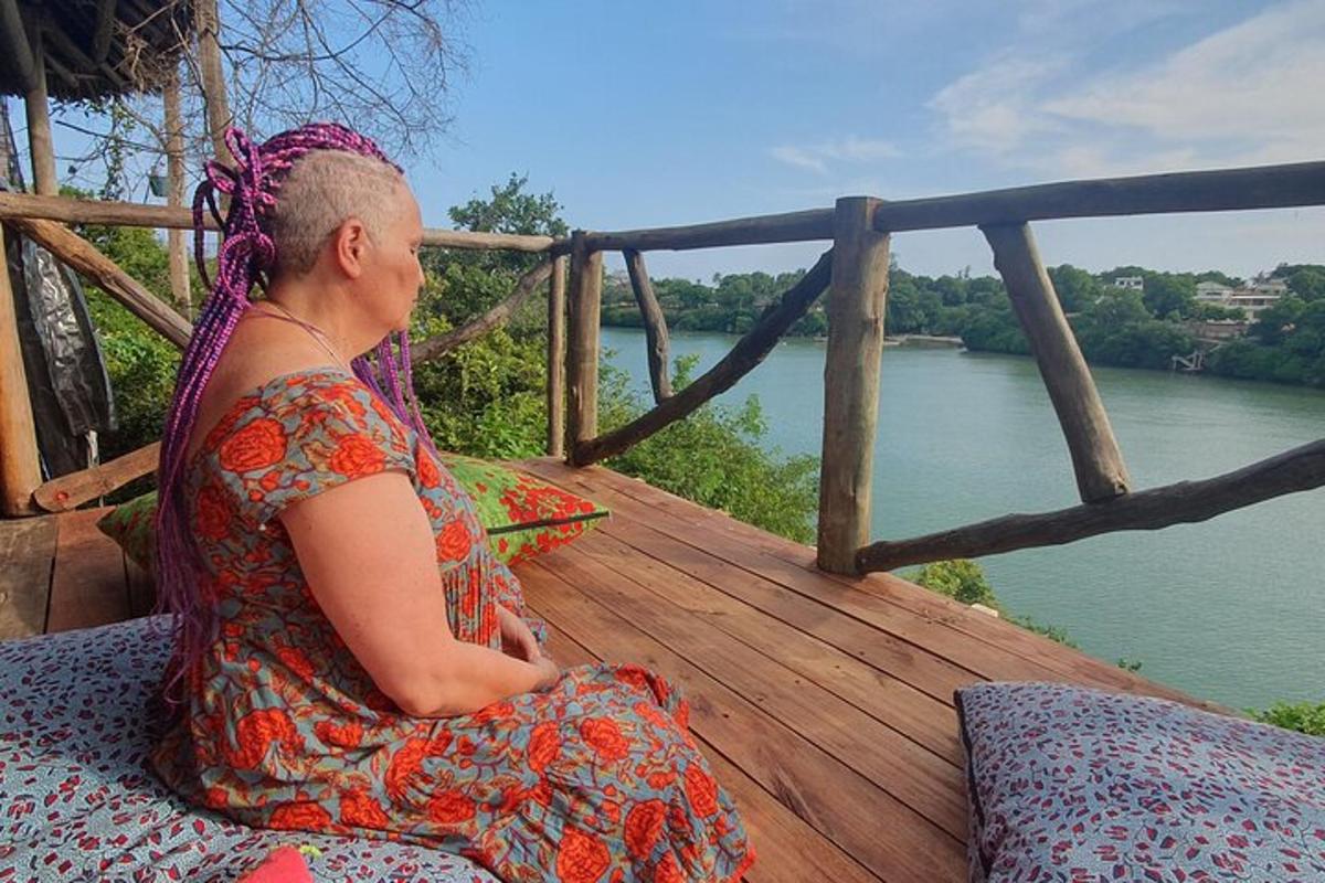 Una mujer sentada en un porche con vistas a un río.