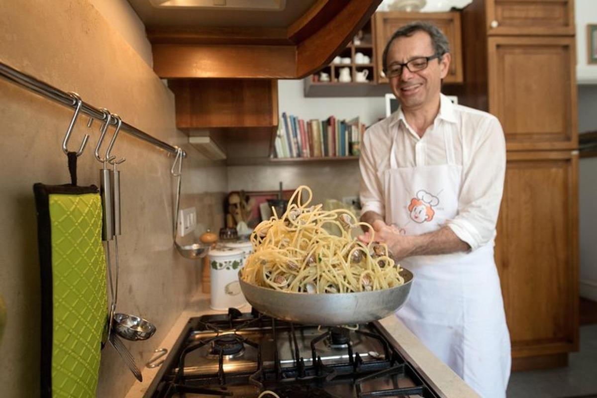 um homem parado em uma cozinha com uma tigela de macarrão
