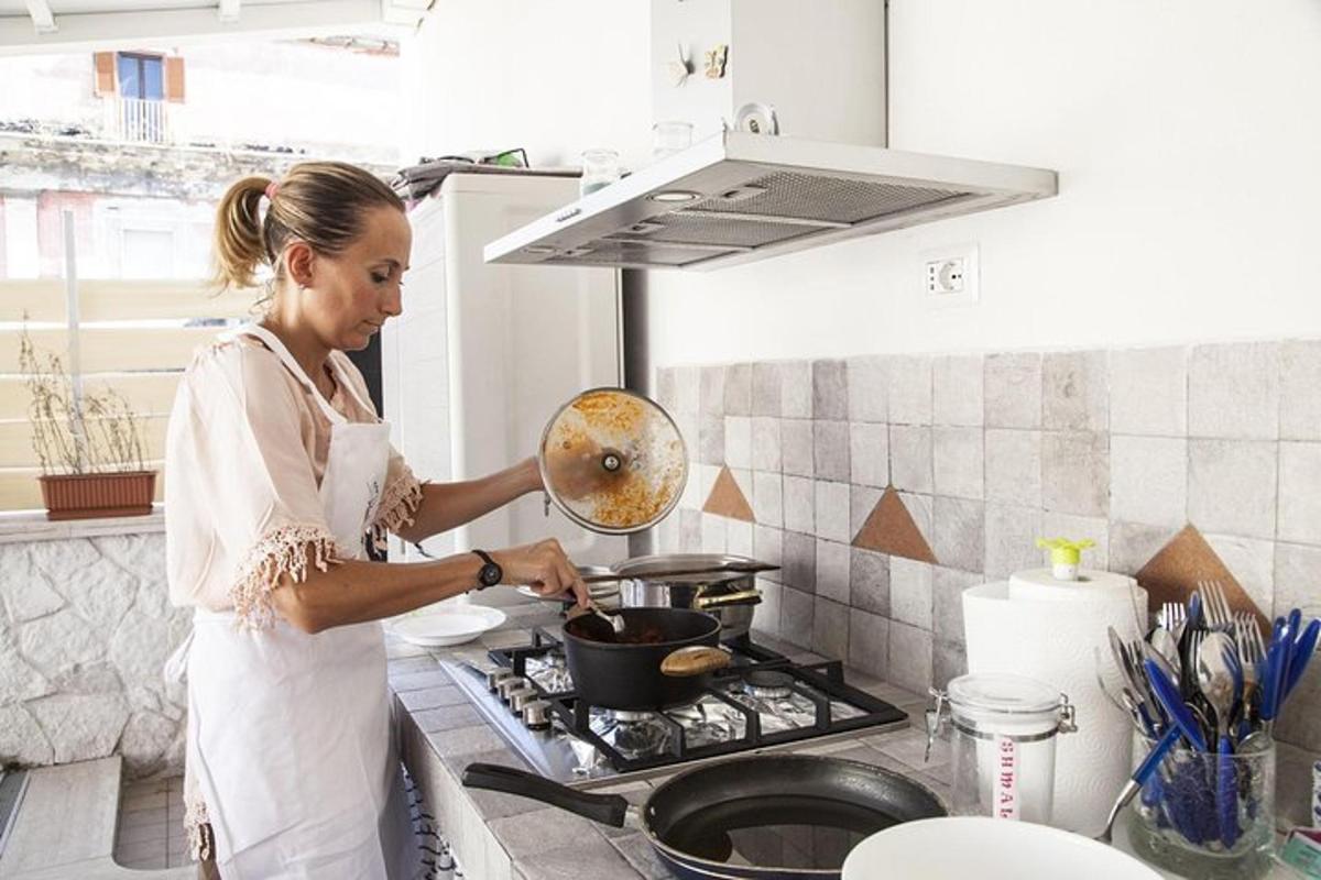 uma mulher na cozinha cozinhando em uma panela no fogão