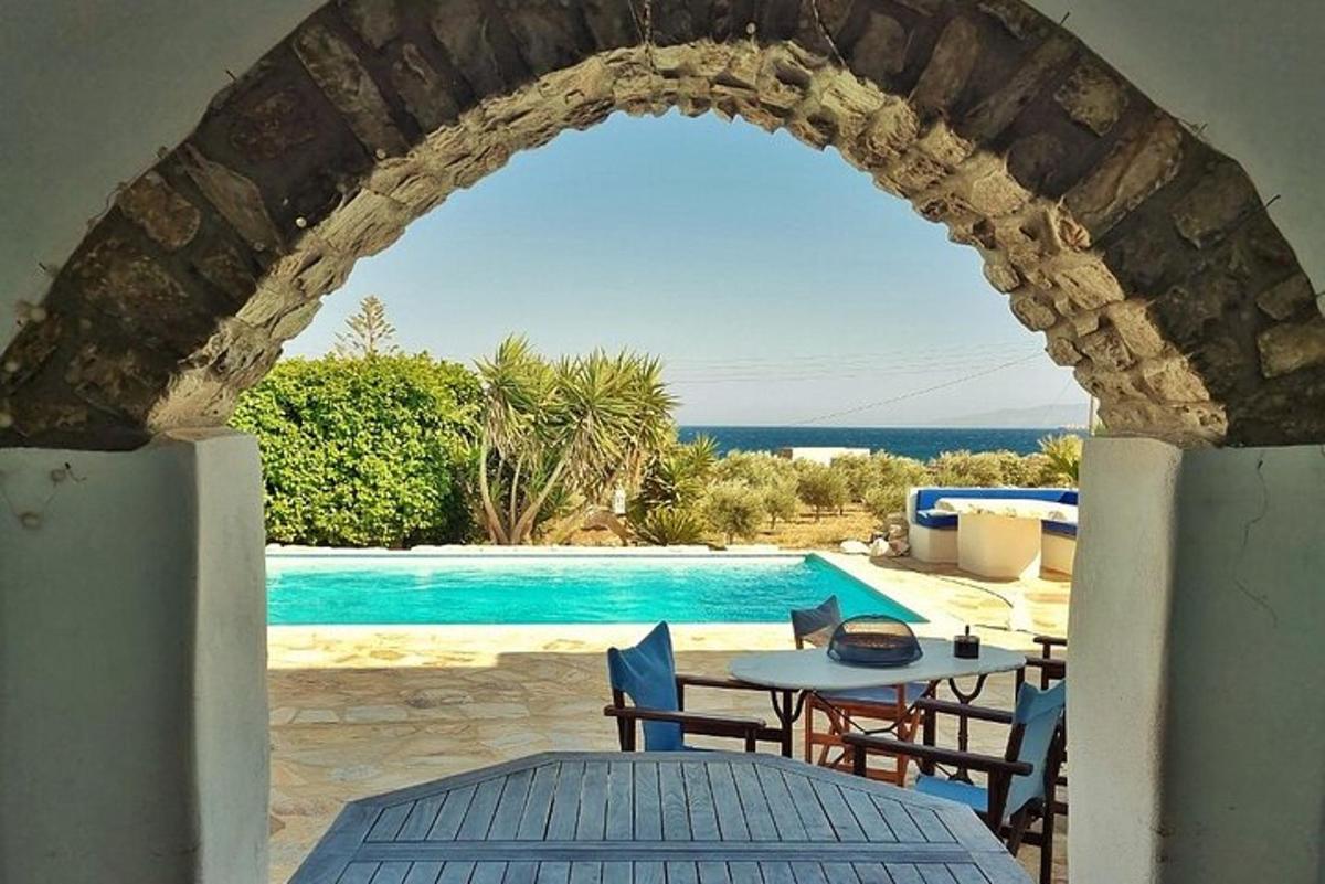 un arco in una casa con un tavolo e una piscina