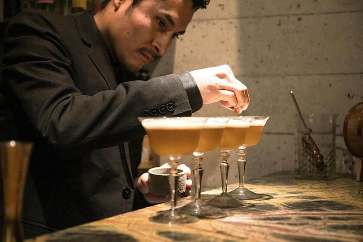 un uomo in giacca e cravatta sta preparando due bicchieri da martini
