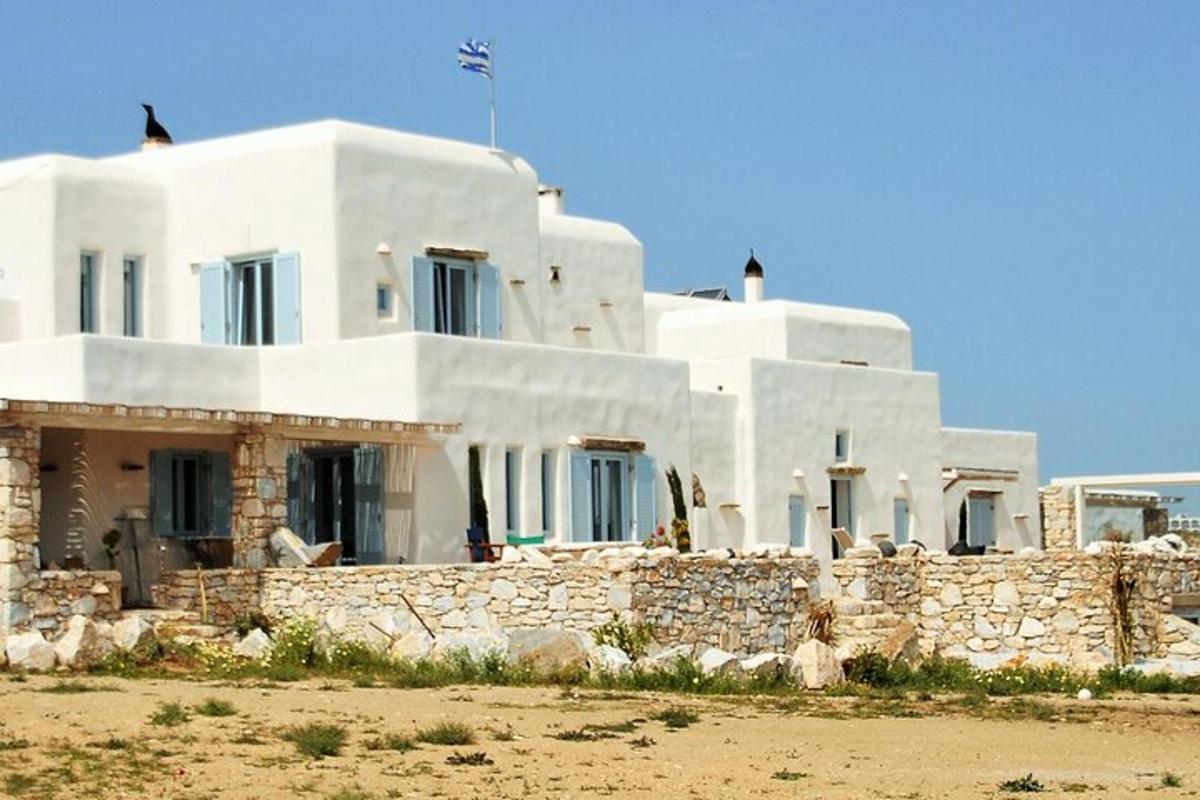 una grande casa bianca con un muro di pietra