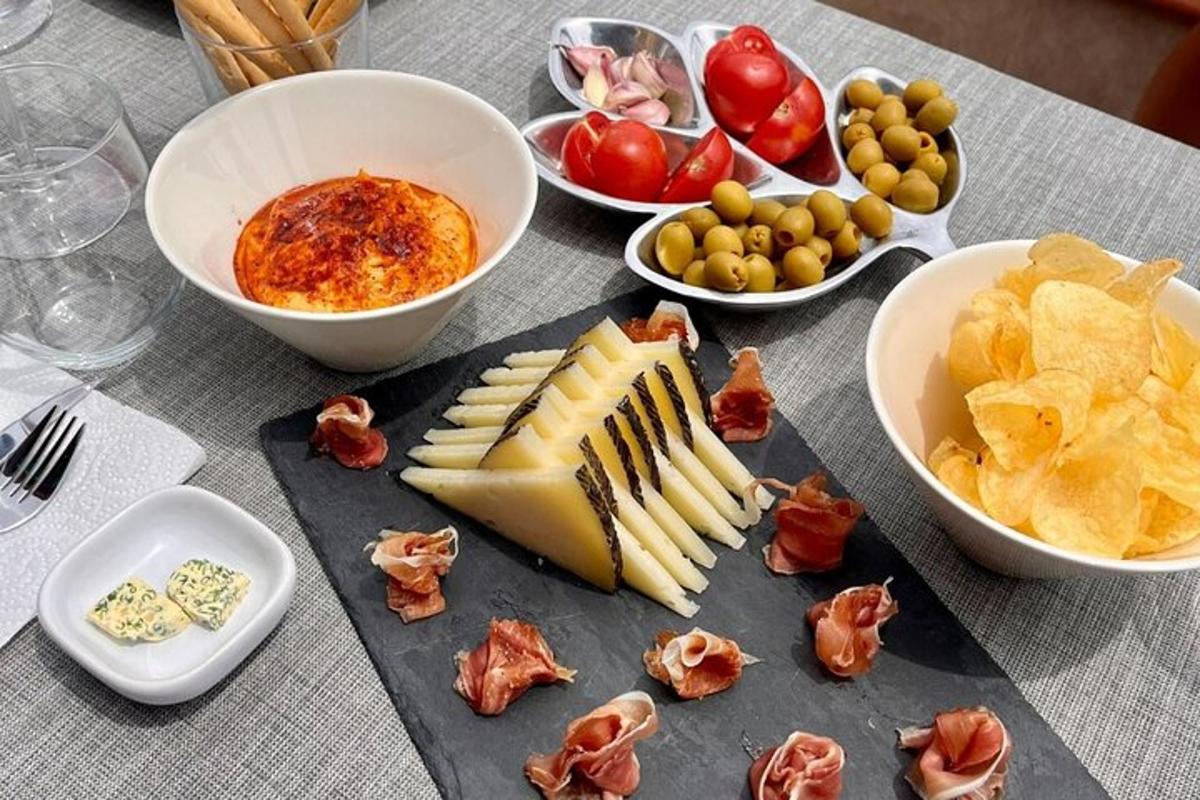una taula amb formatge, patates fregides i bols de menjar