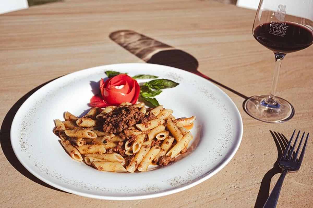 a plate of pasta on a table with a glass of wine