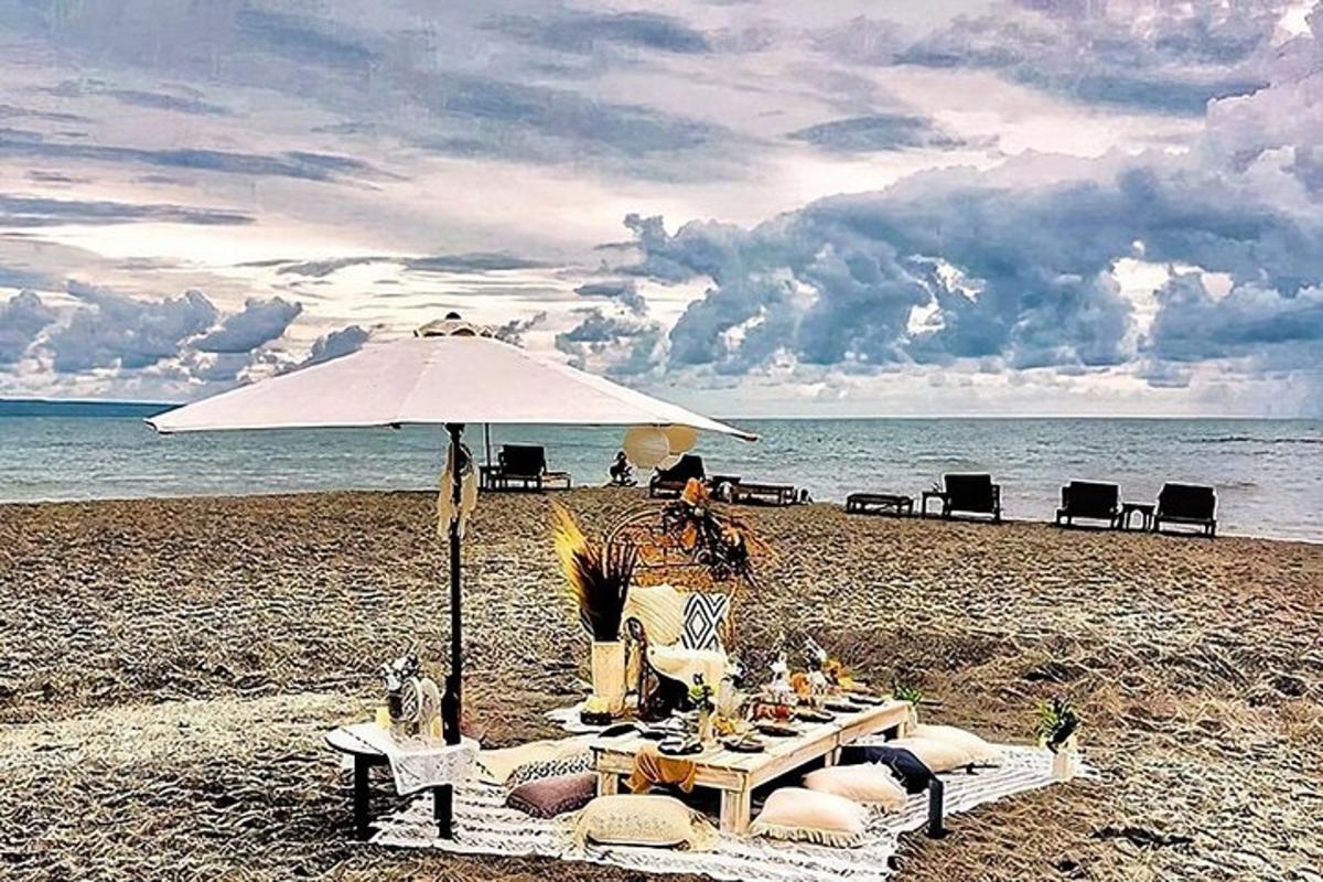 a person sitting in a chair under an umbrella on a beach