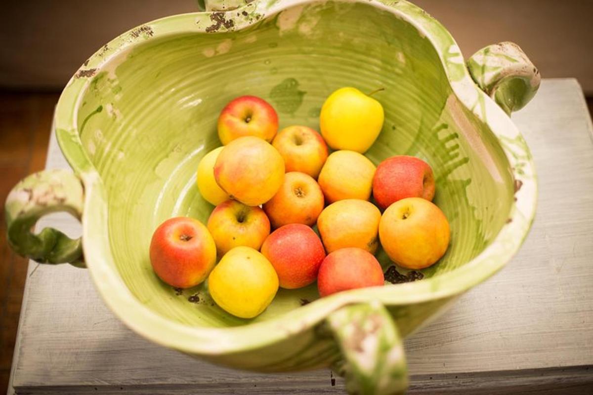 un cesto verde pieno di mele e limoni su un tavolo