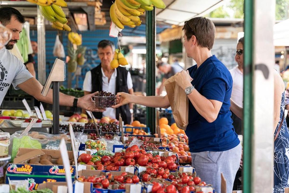 muž podává ženě košík s ovocem na trhu