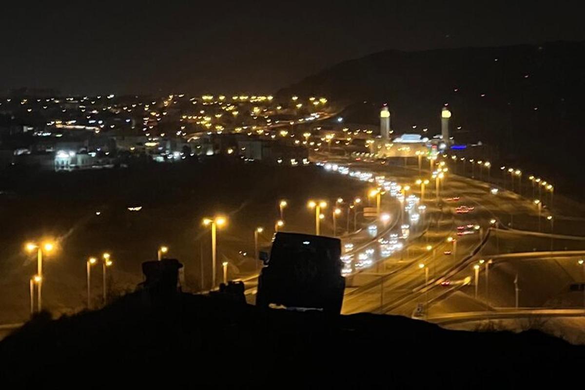 uma cidade iluminada à noite com postes de luz