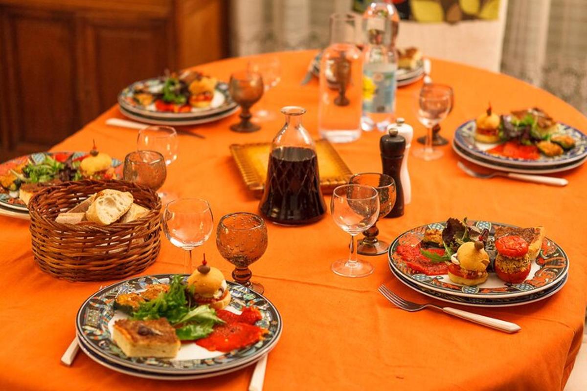 a table with plates of food and wine glasses