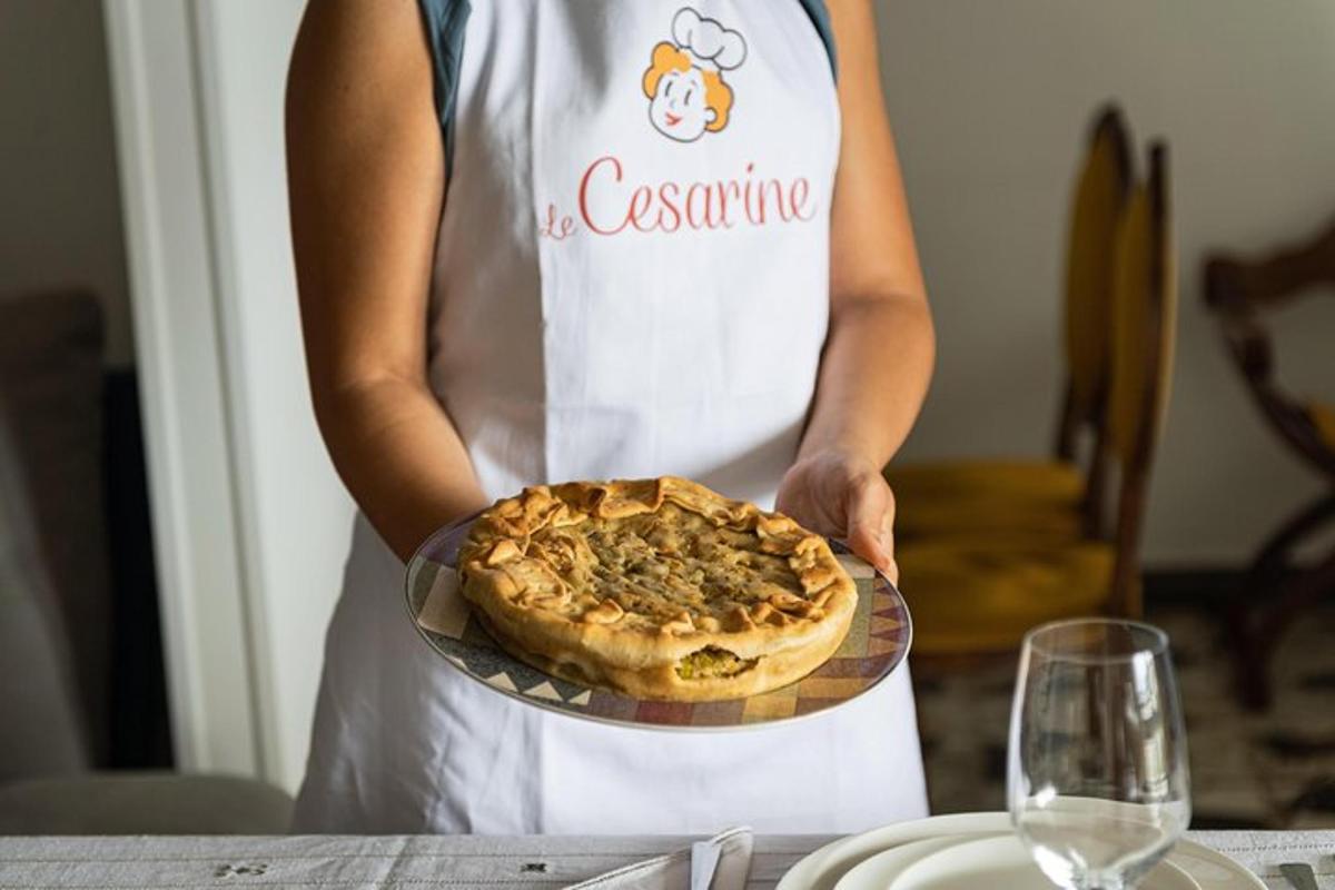 una donna con un grembiule che tiene una pizza su un piatto