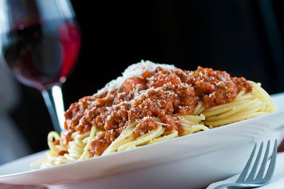 sepinggan pasta dengan sos daging dan segelas wain