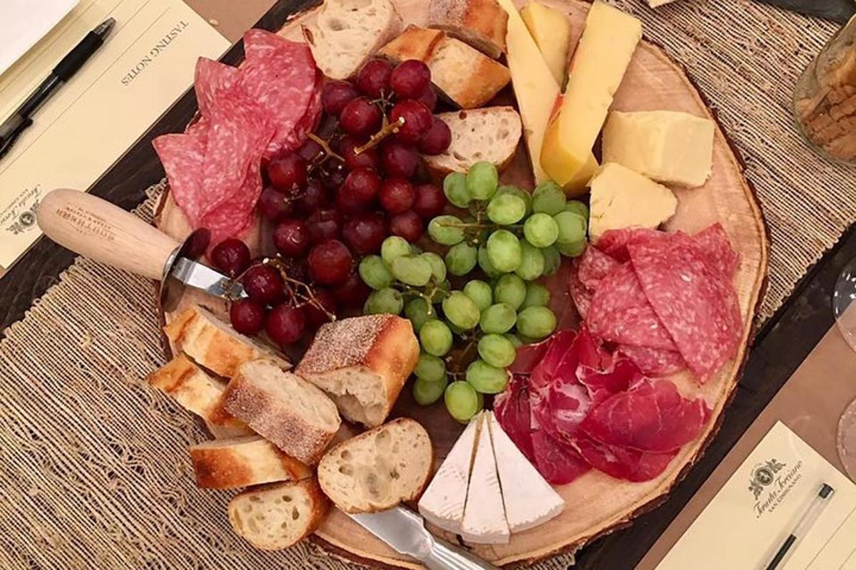 un piatto di cibo con uva, carne e formaggio