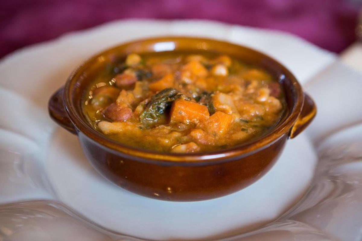 eine braune Schüssel Suppe auf einem weißen Teller