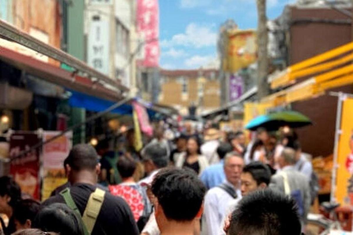 sekumpulan orang berjalan di jalan yang sibuk