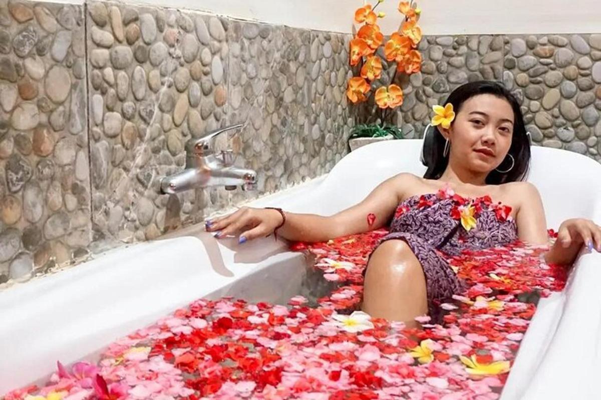 una donna sdraiata in una vasca da bagno ricoperta di fiori