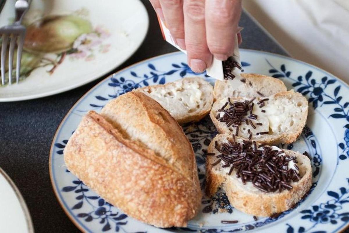 a person eating bread on a blue and white plate