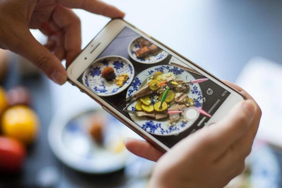 a person taking a picture of a plate of food