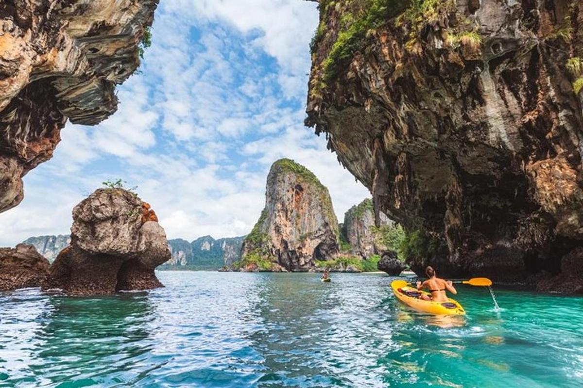a person in a kayak in the water between rocks