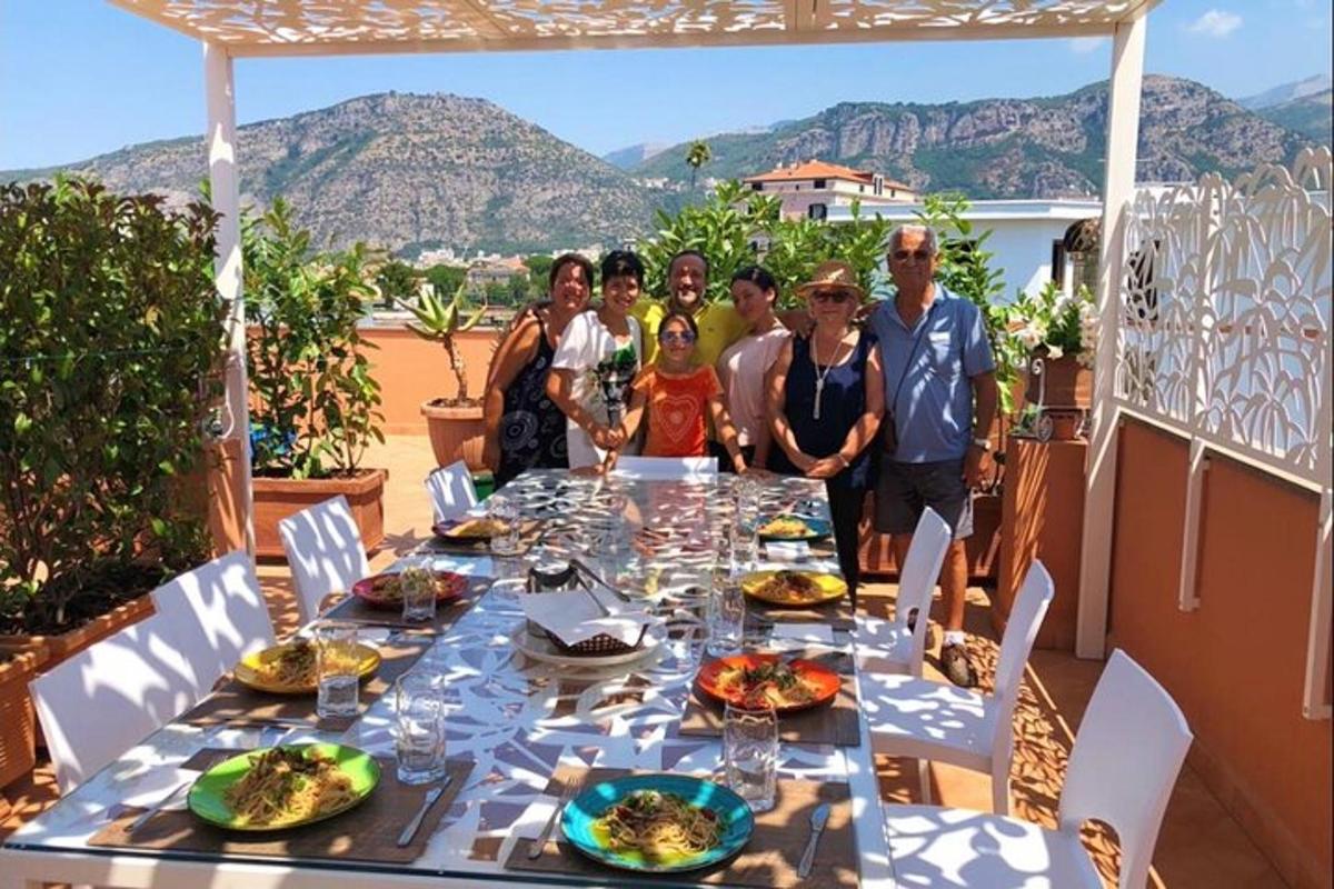 Un grupo de personas de pie alrededor de una mesa con comida.