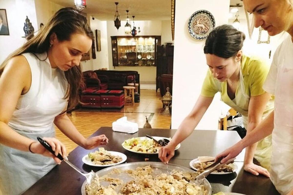 dvě ženy stojící u stolu a připravující jídlo